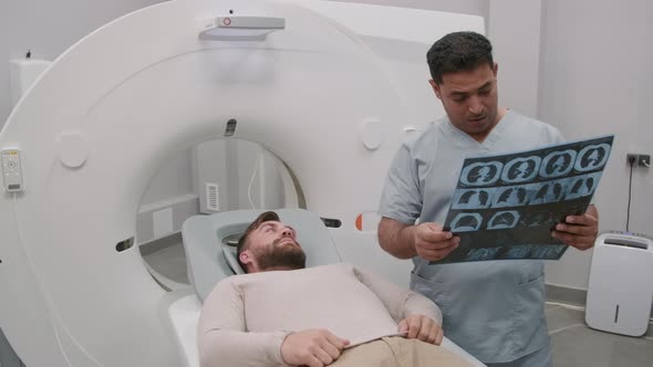 Male Radiologist Reading Chest Scan to Patient