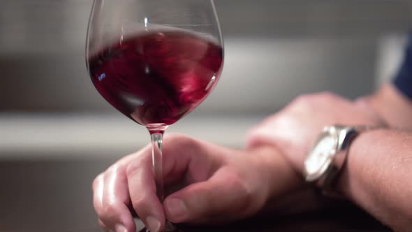 Male hand aerating a glass of red wine