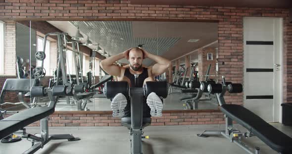 A Strong Man in the Gym with a Pumped Up Body