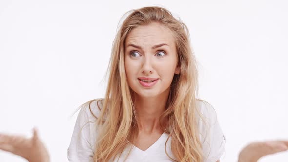 Stressed Young Beautiful Caucasian Blonde Girl Doesn't Understand What Happening on White Background