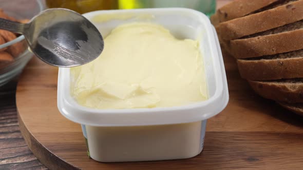 Salted Butter in a Container with Bread on Table