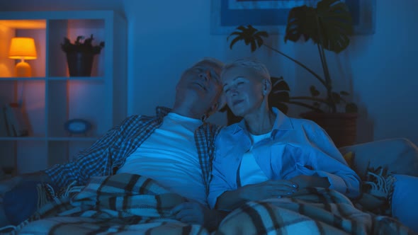 Senior Couple at Home Relaxing on Couch Watching Tv and Talking