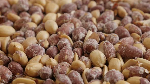 Pile of roasted peanuts on white background 4K 2160p 30fps UltraHD tilting footage - Arachis hypogae