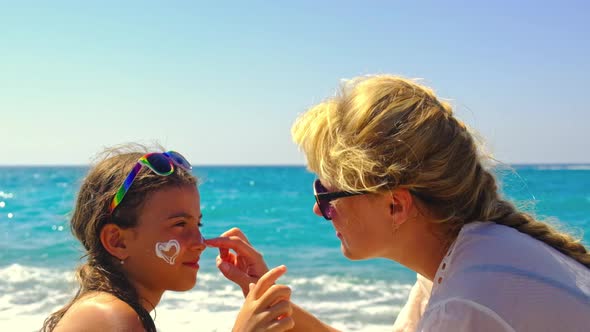 The Mother Smears the Sunscreen on the Baby