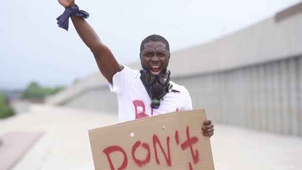 Portrait of Young Male Protester Holding Piece of Cardboard with Text "Don't Shoot"