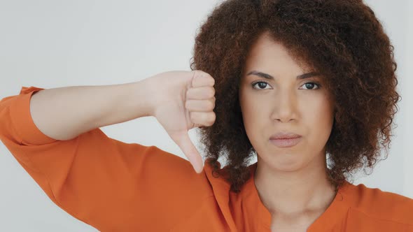 Headshot Portrait Indoor Displeased Millennial Woman with Curly Hair Looking at Camera Showing