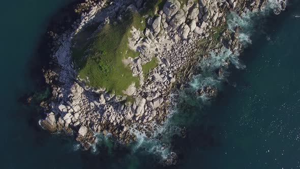 Aerial View of a Beautiful Small Rocky Island Surrounded By Clear Blue Sea