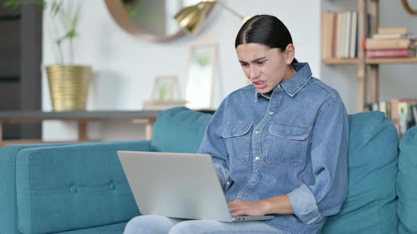 Latin Woman Reacting To Loss on Laptop at Work 