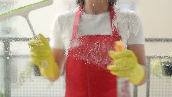 Cleaning Service Worker or Housewife Washes the Windows Using Detergent and Scraper for Cleaning