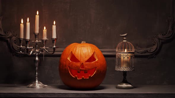 Scary laughing pumpkin and an old skull over the frightening gothic background.