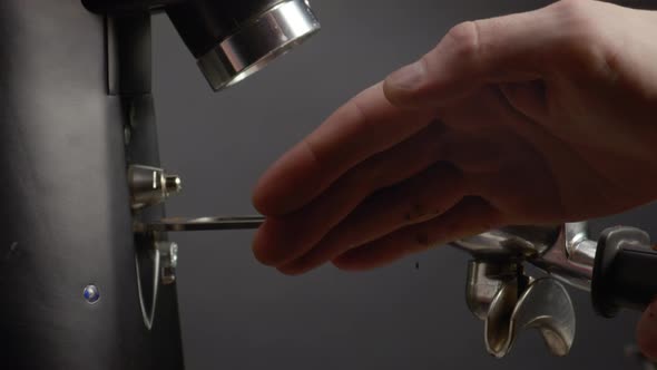 Barista Hand Compacting Ground Coffee Beans in Filter