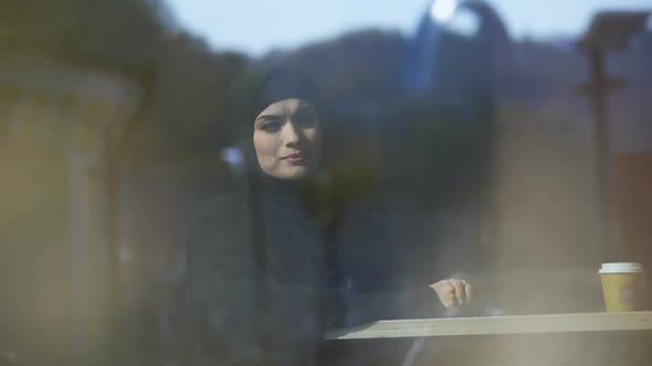 Beautiful Thoughtful Muslim Lady Sitting in Cafe Wearing Hijab Waiting for Order