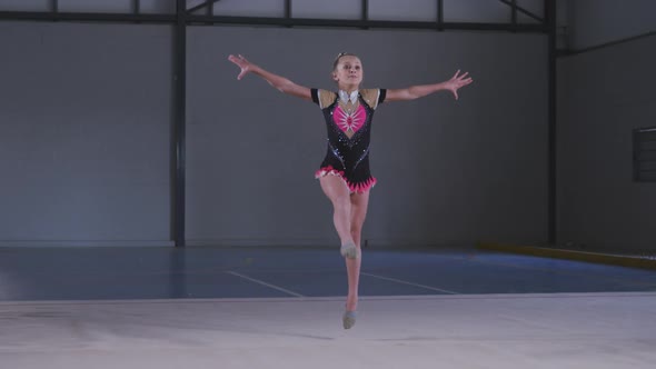 Teenage female gymnast performing at sports hall