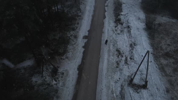 Lonely Man Walking on Pathway During Heavy Snowfall