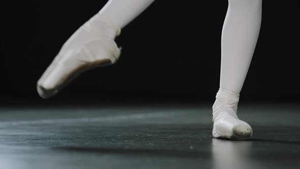 Closeup Female Legs in White Tights and Punts of Ballet Shoes Doing Dance Exercises Pulling