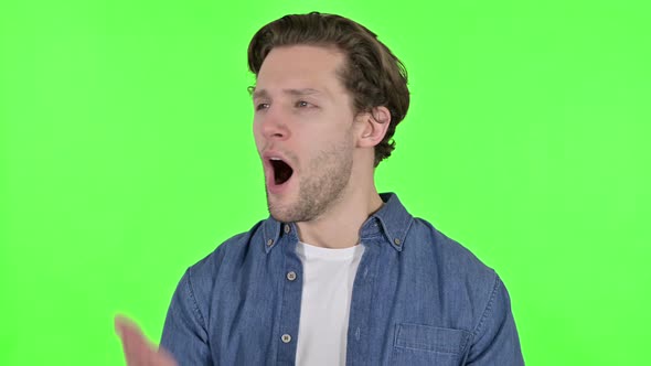 Portrait of Sleepy Young Man Yawning on Green Chroma Key