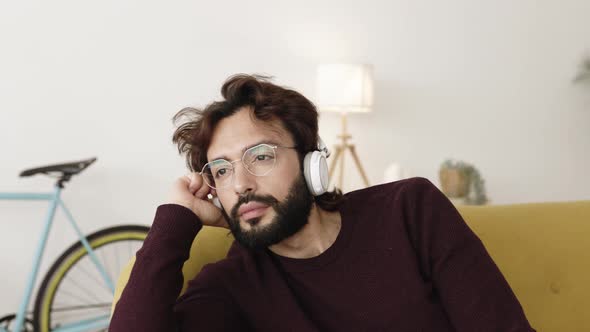 Young Man Relaxing at Home Listening to Music with Headphones