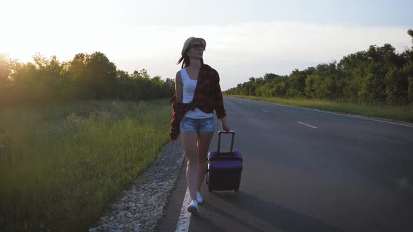 Traveler Woman with Suitcase on Road To Travel. Concept of Travel.