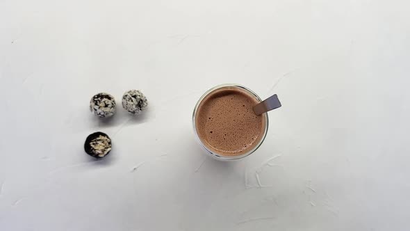 Cup of Hot Chocolate and Three Chocolates on the Table