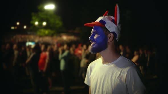 Person with Paint Face Enthusiastically Watche Football Match Background Crowd