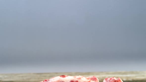 Raw meat chops on wooden board