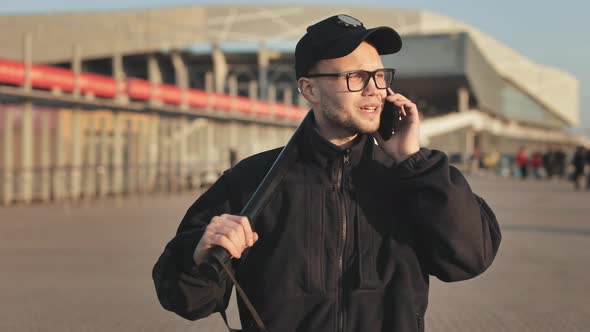 A Man in a Police Uniform is Walking and Seriously Talking on the Phone