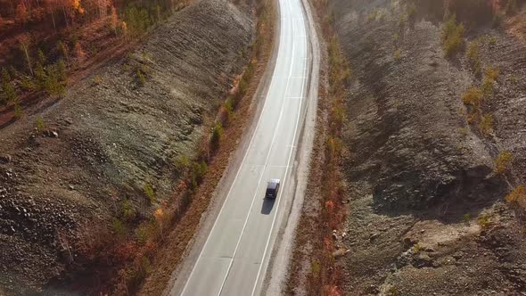 Aerial View of Car Driving on Sunny Fall Country Road Highway.