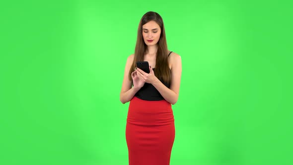 Young Woman Texting on Her Phone and Shocked. Green Screen