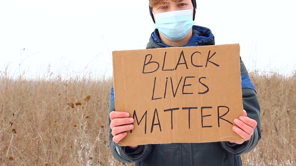 A Caucasian Man Holds a Sign with the Words BLACK LIVES MATTER