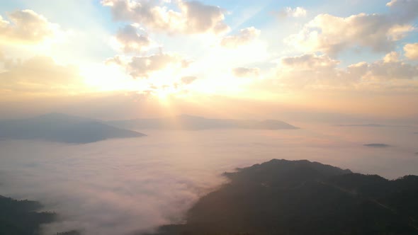 Aerial view from drone, Epic sunbeam over sea of clouds mountains. 4K aerial shot on sunrise