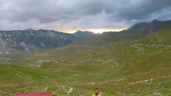 Traveler Standing Beside Red Car Travel with Enjoy on the Mountains in Montenegro