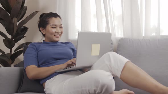 Asian businesswoman authentic shot using a laptop to work from home happily