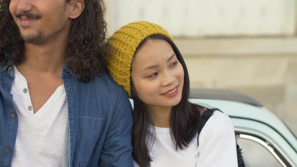 Couple standing in front of a vintage car in Paris, France