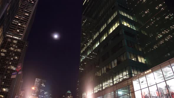 Full moon in night sky over tall skyscrapers, New York City, New York, USA