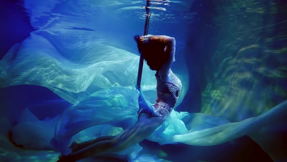 Pole Dancer Like a Mermaid Under Water in an Elegant Dress