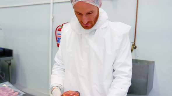 Butcher packing minced meat in container