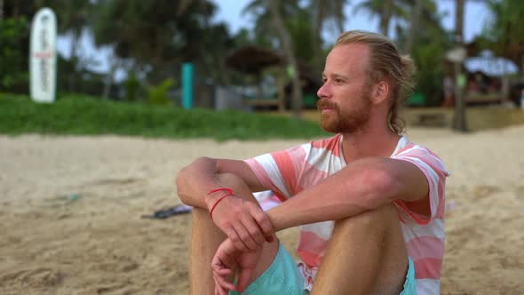 Slowmo Handsome Tanned Blond 30s Bearded Man Tourist Sitting Sand Beach Contemplating Beautiful