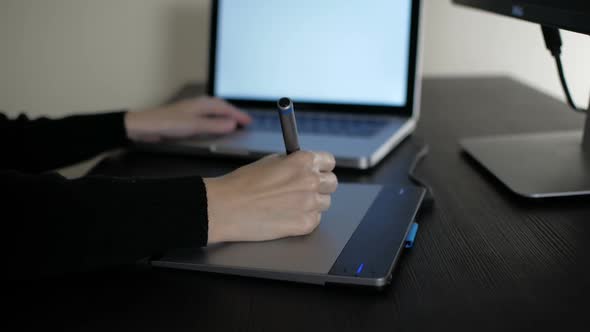 Designer Working On Pen Tablet With Laptop