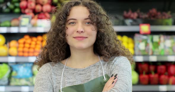 Young Woman Worker in a Vegetable and Fruits Section Supermarket Standing Smiling with Arms Crossed