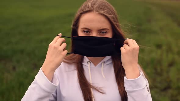 Woman Puts on a Black Mask on Her Face Pandemic Covid19 Coronavirus