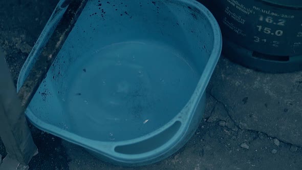 Water Drops Fall Into Large Blue Basin with Clear Water