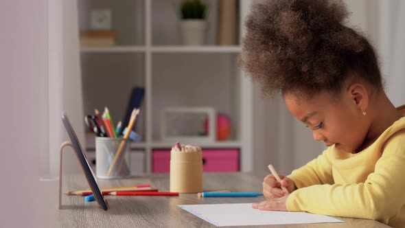 Little Girl Drawing with Coloring Pencils at Home