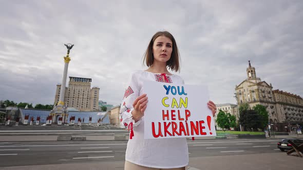 Ukrainian Woman Calls for Support Showing Poster on Maidan