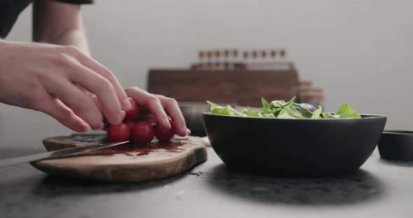 Slow Motion Man Cut Cherry Tomato for Salad on Kitchen Countertop