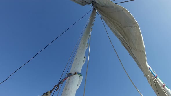 Crew member raising sail on felucca boat