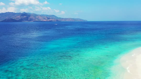 Beautiful flying clean view of a white sandy paradise beach and aqua blue water background in colorf