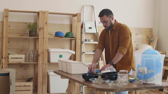 Middle-aged Man Sorting Multicolor Plastic Caps