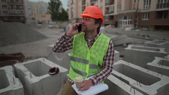 Male Builder Foreman Worker or Architect Working on Construction Building Site Drinking Tea or