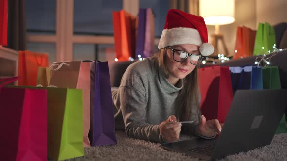 Happy Woman Glasses Wearing Santa Claus Hat Is Lying Carpet Makes Online Purchase Using Credit Card