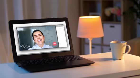 Laptop with Video Call on Screen on Table at Night